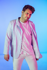 Image showing Young caucasian musician, dancer, party host, DJ on gradient background in neon light