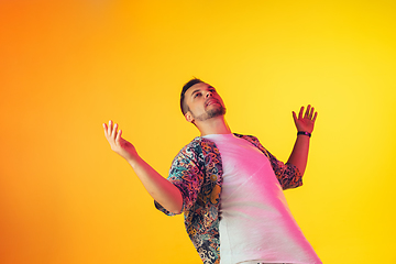 Image showing Young caucasian musician, dancer, party host, DJ on gradient background in neon light