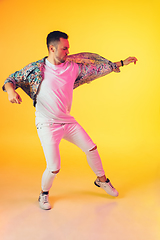 Image showing Young caucasian musician, dancer, party host, DJ on gradient background in neon light