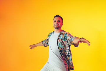 Image showing Young caucasian musician, dancer, party host, DJ on gradient background in neon light