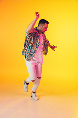 Image showing Young caucasian musician, dancer, party host, DJ on gradient background in neon light