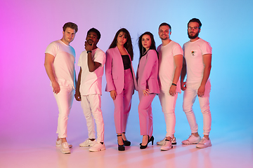 Image showing Group of young multiethnic musicians created band, posing in neon light on gradient background