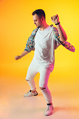 Image showing Young caucasian musician, dancer, party host, DJ on gradient background in neon light