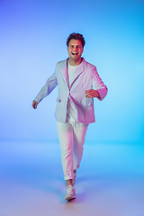 Image showing Young caucasian musician, dancer, party host, DJ on gradient background in neon light