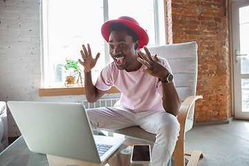 Image showing African-american man during videocall with his band sitting at home, musicians during quarantine and insulation