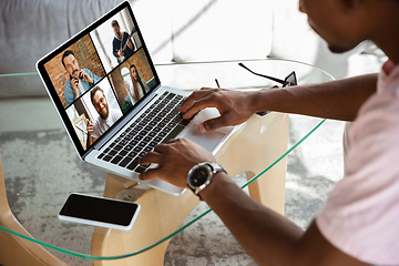 Image showing African-american man during videocall with his band sitting at home, musicians during quarantine and insulation