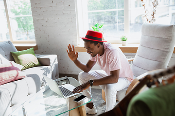 Image showing African-american man during videocall with his band sitting at home, musicians during quarantine and insulation