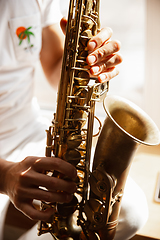 Image showing Close up of caucasian musician playing saxophone during concert at home isolated and quarantined
