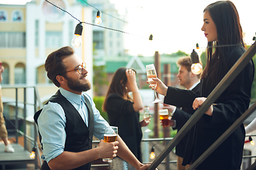 Image showing Group of young caucasian people celebrating, look happy, have corporate party at office or bar