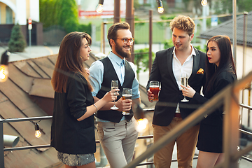 Image showing Group of young caucasian people celebrating, look happy, have corporate party at office or bar