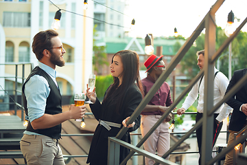 Image showing Group of young caucasian people celebrating, look happy, have corporate party at office or bar