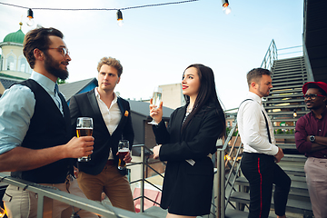 Image showing Group of young caucasian people celebrating, look happy, have corporate party at office or bar