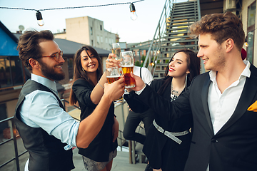 Image showing Group of young caucasian people celebrating, look happy, have corporate party at office or bar
