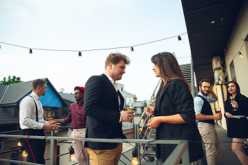 Image showing Group of young caucasian people celebrating, look happy, have corporate party at office or bar