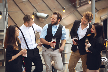 Image showing Group of young caucasian people celebrating, look happy, have corporate party at office or bar