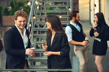 Image showing Group of young caucasian people celebrating, look happy, have corporate party at office or bar