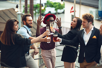 Image showing Multiethnic group of people celebrating, look happy, have corporate party at office or bar