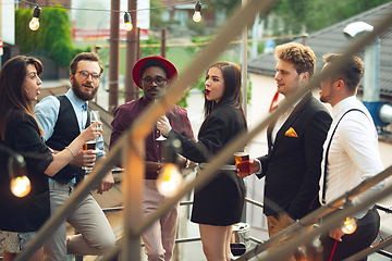 Image showing Multiethnic group of people celebrating, look happy, have corporate party at office or bar