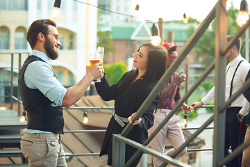 Image showing Group of young caucasian people celebrating, look happy, have corporate party at office or bar