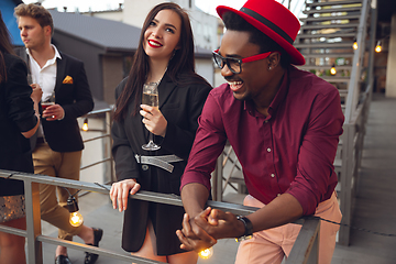 Image showing Group of young people celebrating, look happy, have corporate party at office or bar