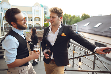 Image showing Two men talking, celebrating, look happy, have corporate party at office or bar