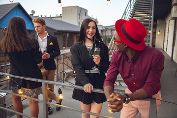 Image showing Group of young people celebrating, look happy, have corporate party at office or bar