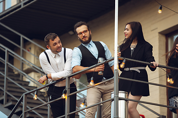 Image showing Group of young caucasian people celebrating, look happy, have corporate party at office or bar