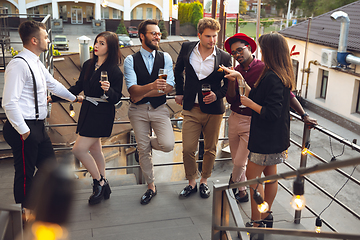 Image showing Multiethnic group of people celebrating, look happy, have corporate party at office or bar