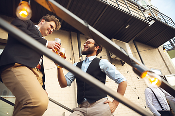 Image showing Two men talking, celebrating, look happy, have corporate party at office or bar