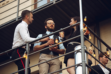 Image showing Group of young caucasian people celebrating, look happy, have corporate party at office or bar