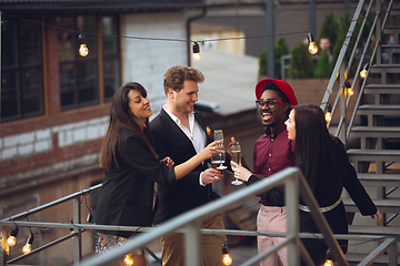 Image showing Multiethnic group of people celebrating, look happy, have corporate party at office or bar