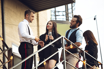 Image showing Group of young caucasian people celebrating, look happy, have corporate party at office or bar