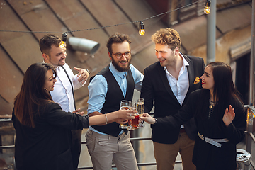 Image showing Group of young caucasian people celebrating, look happy, have corporate party at office or bar