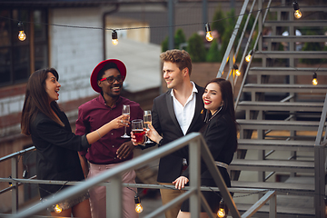 Image showing Multiethnic group of people celebrating, look happy, have corporate party at office or bar