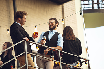 Image showing Group of young caucasian people celebrating, look happy, have corporate party at office or bar