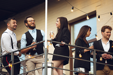 Image showing Group of young caucasian people celebrating, look happy, have corporate party at office or bar