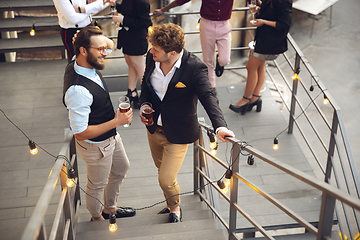 Image showing Two men talking, celebrating, look happy, have corporate party at office or bar