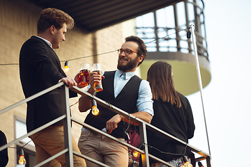 Image showing Two men talking, celebrating, look happy, have corporate party at office or bar