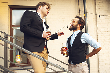 Image showing Two men talking, celebrating, look happy, have corporate party at office or bar