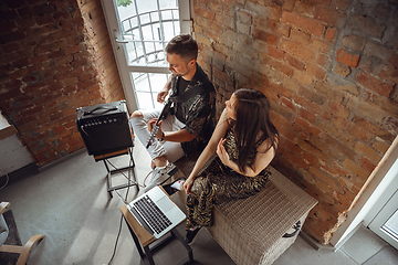 Image showing Caucasian musicians during online concert at home insulated and quarantined, cheerful and happy, top view