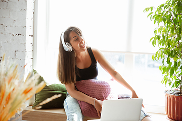 Image showing Caucasian female singer during online concert at home insulated and quarantined, cheerful and happy, singing live, performing