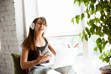 Image showing Caucasian female singer during online concert at home insulated and quarantined, cheerful and happy, singing live, performing