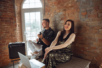 Image showing Caucasian musicians during online concert at home insulated and quarantined, cheerful and happy, impressive improvising