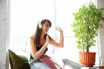 Image showing Caucasian female singer during online concert at home insulated and quarantined, cheerful and happy, singing live, performing