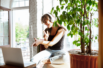 Image showing Caucasian female singer during online concert at home insulated and quarantined, cheerful and happy, singing live, performing