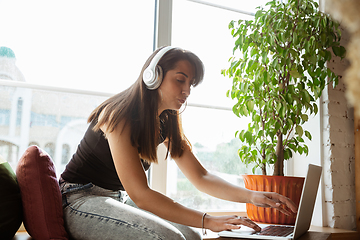 Image showing Caucasian female singer during online concert at home insulated and quarantined, cheerful and happy, preparing for perfomance