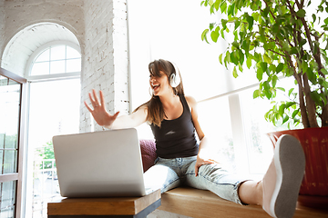 Image showing Caucasian female singer during online concert at home insulated and quarantined, cheerful and happy, singing live, performing