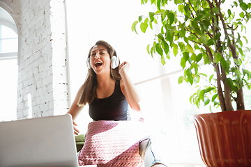 Image showing Caucasian female singer during online concert at home insulated and quarantined, cheerful and happy, singing live, performing