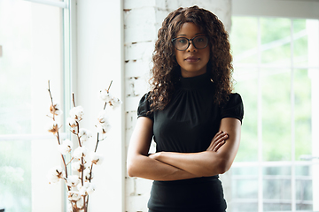 Image showing Beautiful african-american well-dressed businesswoman looks confident and busy, successful