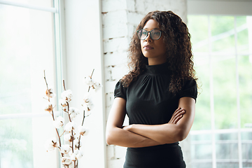 Image showing Beautiful african-american well-dressed businesswoman looks confident and busy, successful